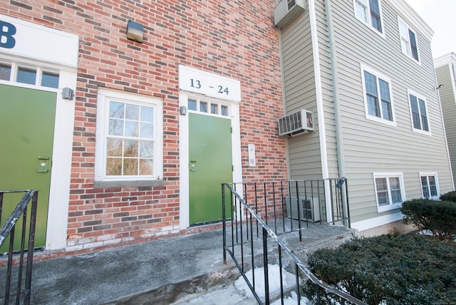 view of exterior entry with a wall mounted AC