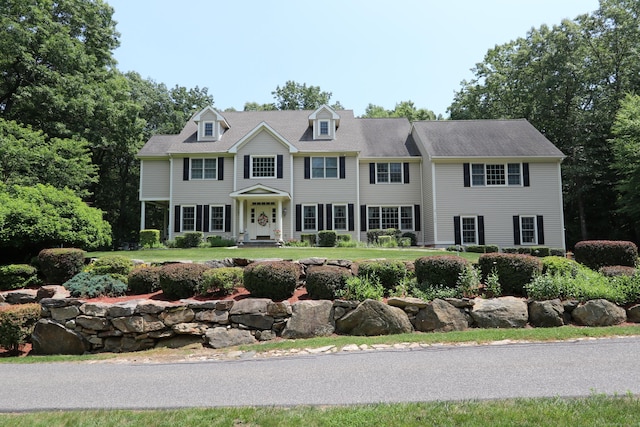 colonial inspired home featuring a front lawn