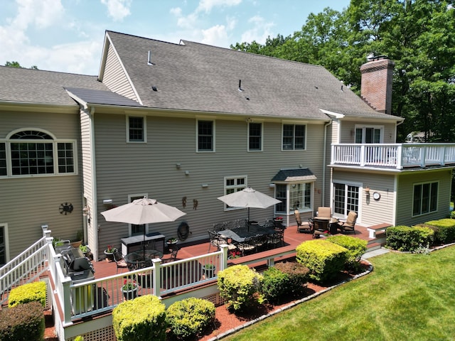 rear view of house with a wooden deck and a yard