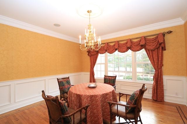 dining room with ornamental molding, light hardwood / wood-style floors, and a notable chandelier