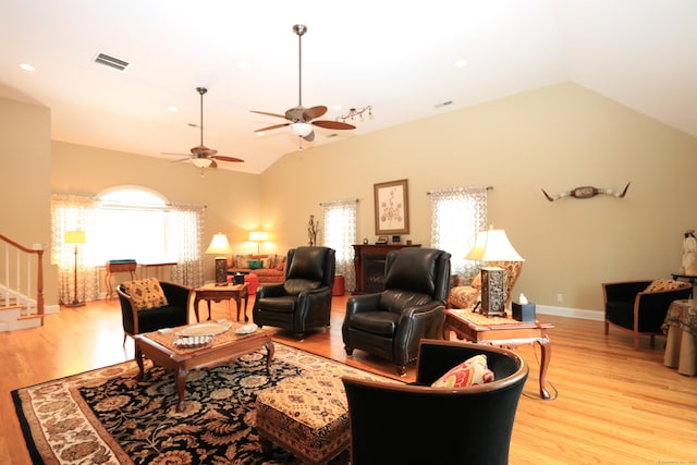 living room with ceiling fan, lofted ceiling, and light hardwood / wood-style flooring