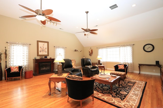 living room featuring lofted ceiling, ceiling fan, and light wood-type flooring