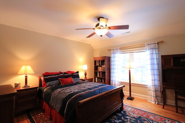 bedroom with ceiling fan, lofted ceiling, and light hardwood / wood-style flooring