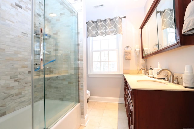 full bathroom featuring vanity, tile patterned flooring, bath / shower combo with glass door, and toilet