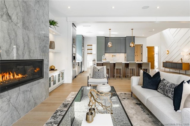 living room with a fireplace and light wood-type flooring