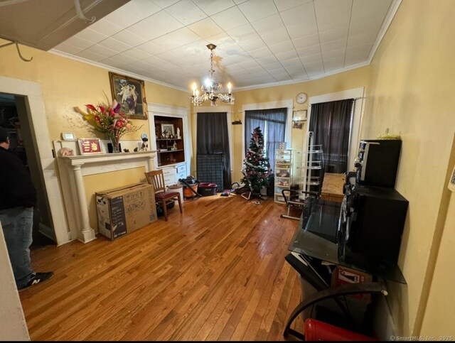 misc room featuring crown molding, hardwood / wood-style floors, and a notable chandelier