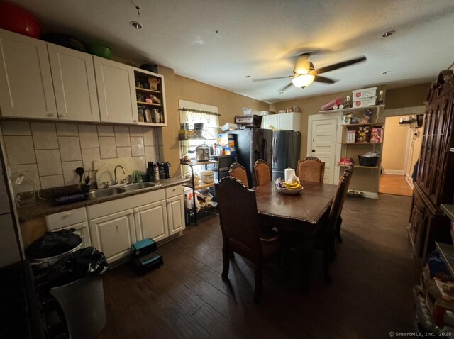 dining room with dark hardwood / wood-style flooring, sink, and ceiling fan