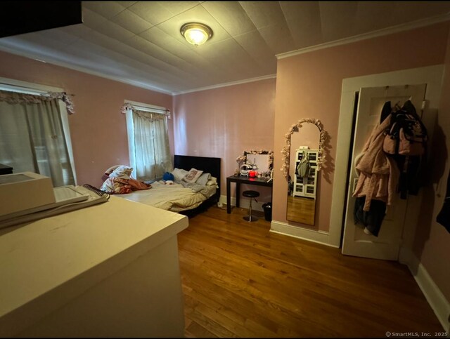 bedroom with hardwood / wood-style floors and ornamental molding