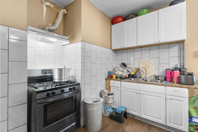 kitchen with extractor fan, stainless steel range with gas cooktop, sink, and white cabinets