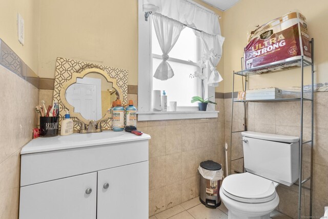 bathroom with vanity, tile walls, tile patterned floors, and toilet