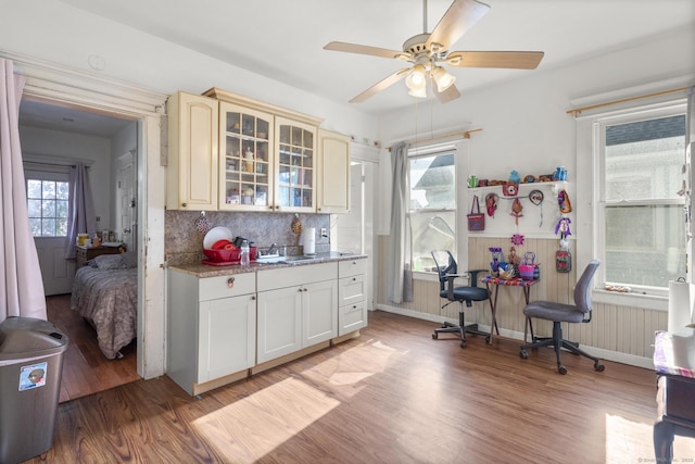 kitchen featuring radiator heating unit, tasteful backsplash, sink, light wood-type flooring, and cream cabinetry