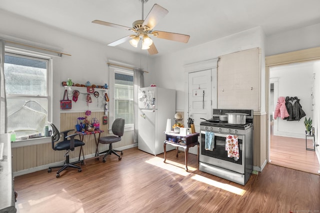 kitchen with hardwood / wood-style flooring, plenty of natural light, gas stove, and white refrigerator