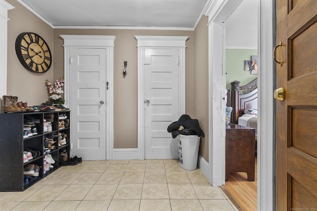 entryway featuring light tile patterned floors and ornamental molding