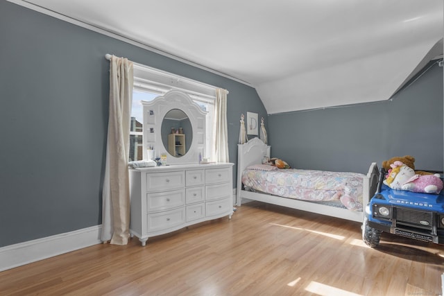 bedroom with vaulted ceiling and light hardwood / wood-style floors