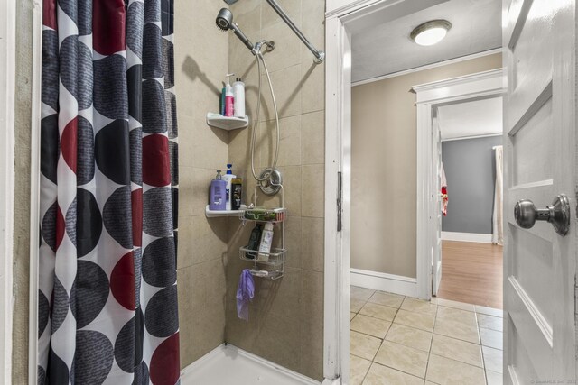 bathroom with a shower with curtain, tile patterned floors, and crown molding