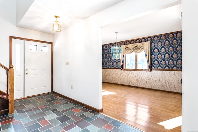 foyer entrance with dark hardwood / wood-style flooring and a chandelier