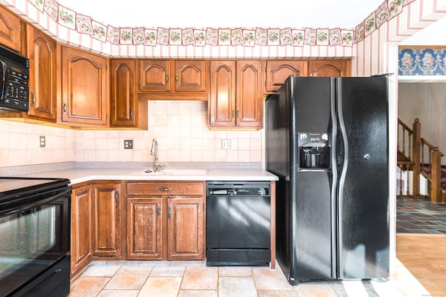 kitchen featuring sink, decorative backsplash, and black appliances