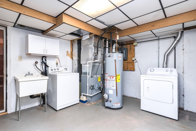 basement with water heater, washing machine and dryer, a paneled ceiling, and heating unit