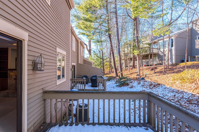 snow covered deck featuring central AC unit