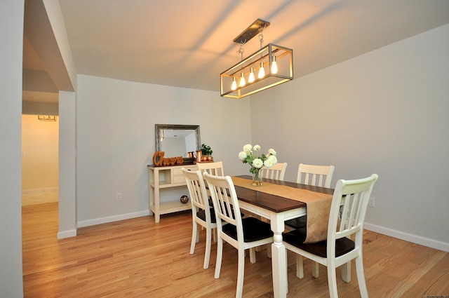 dining area featuring a chandelier and light wood-type flooring