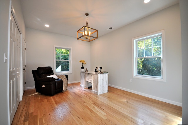 living area with a chandelier and light wood-type flooring