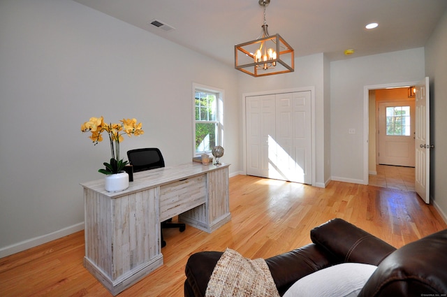 office with plenty of natural light, a chandelier, and light wood-type flooring