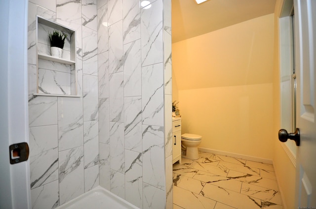 bathroom with vanity, tiled shower, and toilet