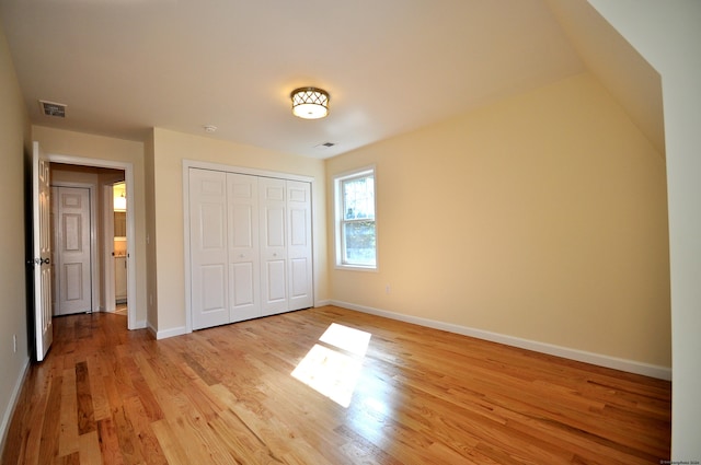 unfurnished bedroom featuring light hardwood / wood-style floors and a closet