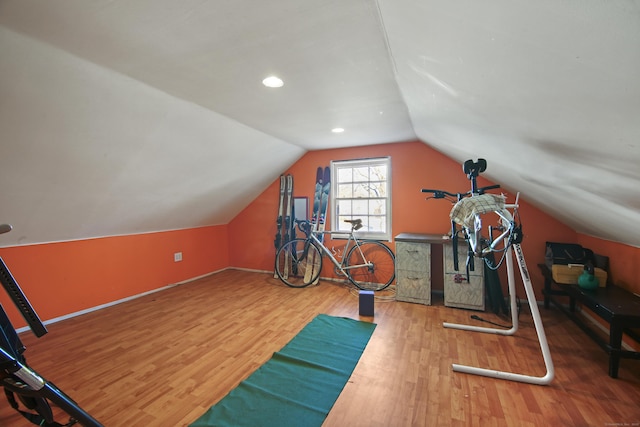 workout room featuring wood-type flooring and vaulted ceiling