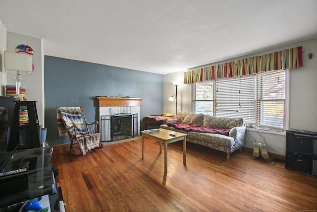 living room with hardwood / wood-style flooring and a brick fireplace