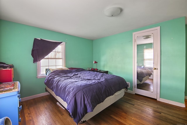 bedroom with dark hardwood / wood-style flooring