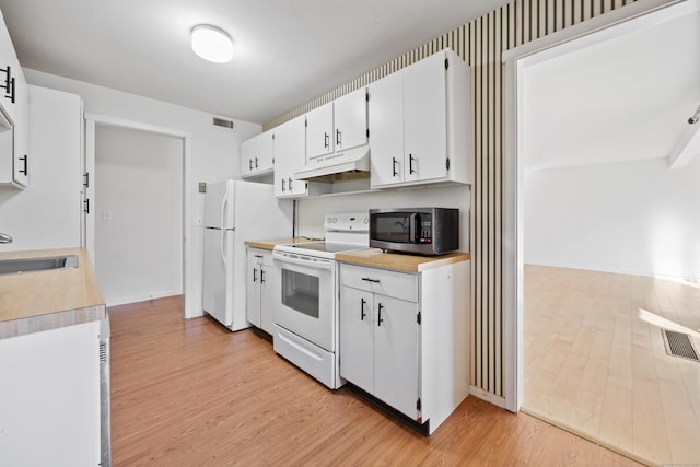 kitchen with sink, white cabinets, white appliances, and light hardwood / wood-style floors