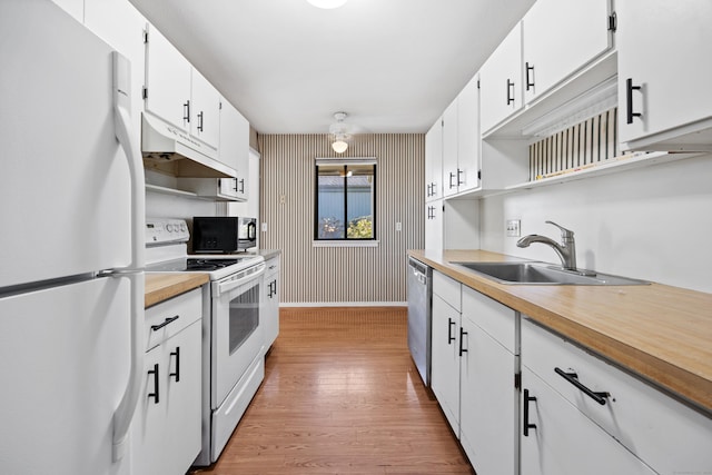 kitchen featuring white appliances, sink, light hardwood / wood-style flooring, and white cabinets