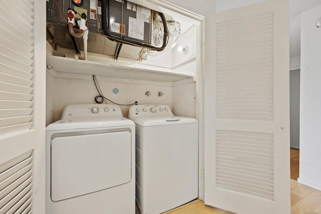 washroom with washing machine and dryer and light hardwood / wood-style flooring