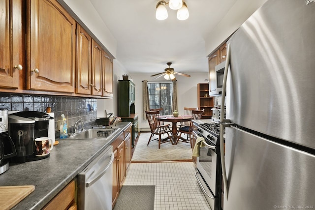 kitchen with sink, light tile patterned floors, ceiling fan, appliances with stainless steel finishes, and tasteful backsplash