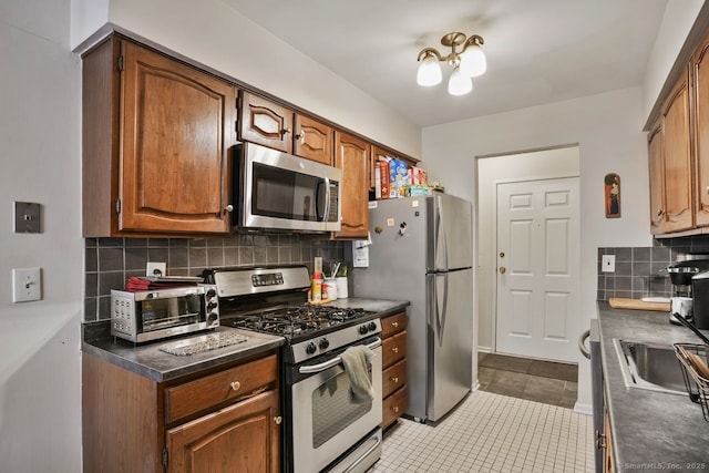 kitchen featuring tasteful backsplash, light tile patterned floors, sink, and appliances with stainless steel finishes