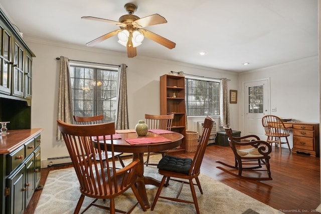 dining area featuring dark hardwood / wood-style flooring, ornamental molding, and ceiling fan