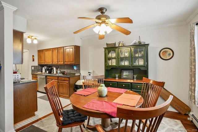 dining room with sink, ornamental molding, and ceiling fan