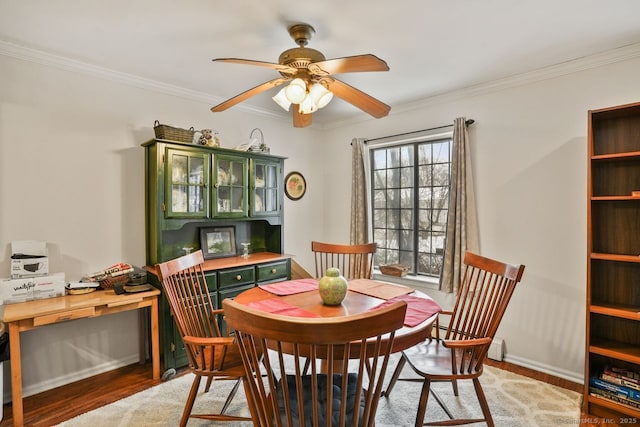 dining room with wood-type flooring, ornamental molding, and ceiling fan