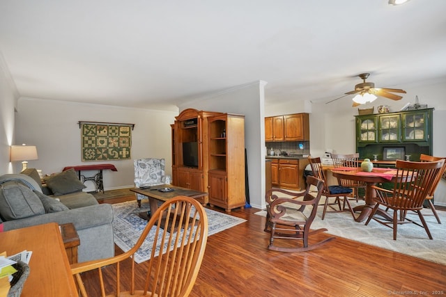 living room featuring crown molding, hardwood / wood-style flooring, and ceiling fan