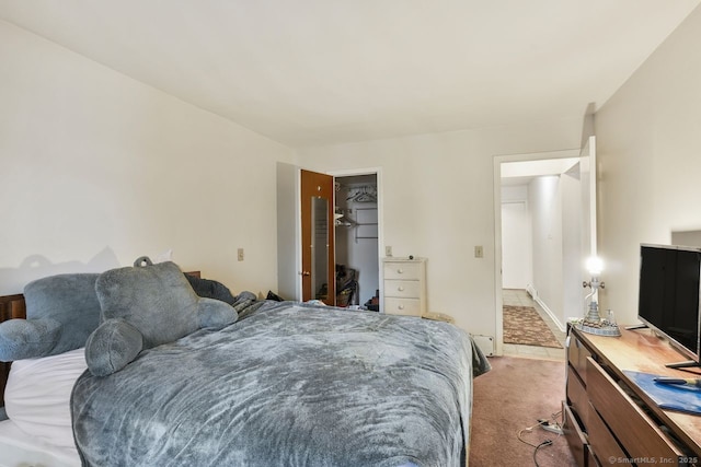 carpeted bedroom featuring a walk in closet