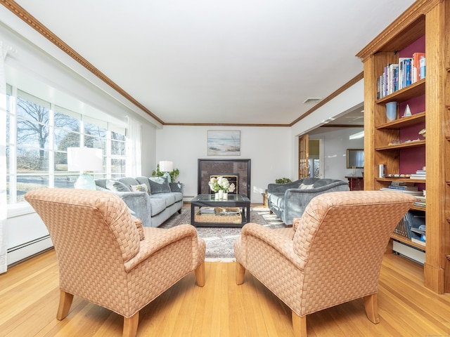 living room featuring baseboard heating, crown molding, and light wood-type flooring