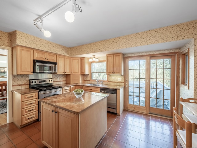 kitchen featuring appliances with stainless steel finishes, a center island, sink, and light brown cabinets