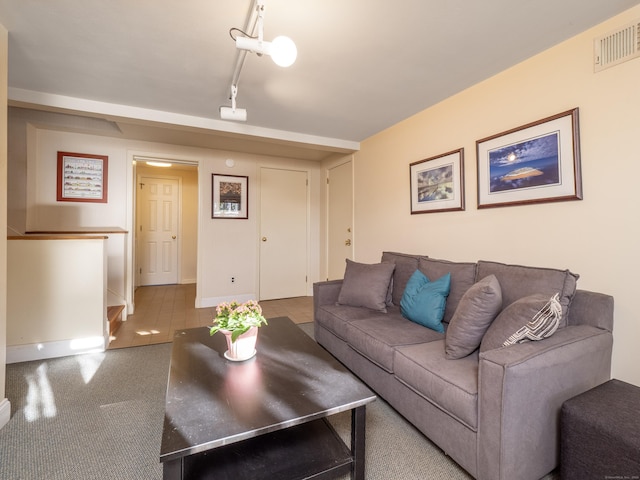 carpeted living room with rail lighting