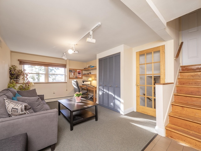 carpeted living room featuring a baseboard radiator and rail lighting