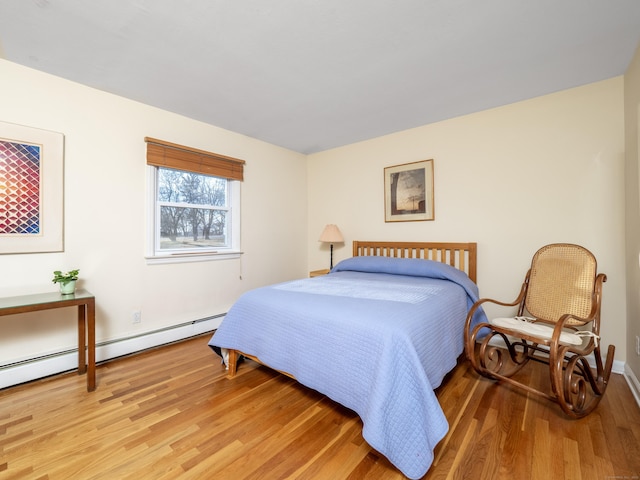 bedroom featuring a baseboard radiator and hardwood / wood-style floors