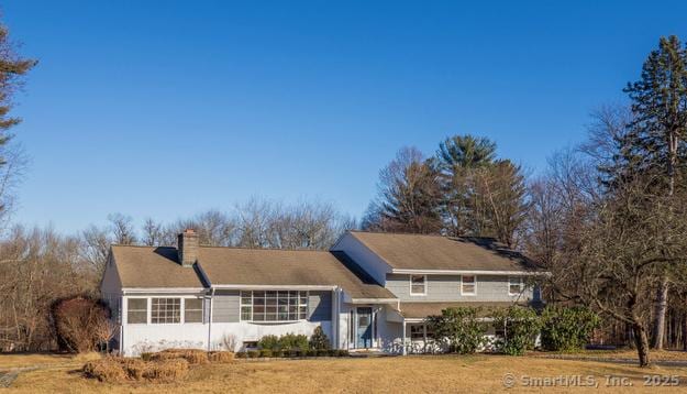 rear view of house featuring a yard