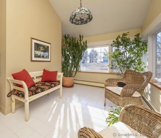 living area featuring a healthy amount of sunlight, lofted ceiling, and a baseboard heating unit