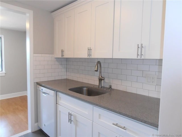 kitchen featuring tasteful backsplash, white cabinetry, dishwasher, sink, and hardwood / wood-style flooring