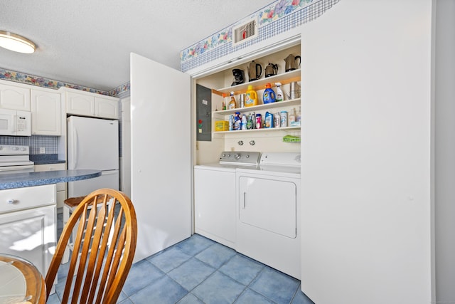 clothes washing area featuring independent washer and dryer, electric panel, a textured ceiling, and light tile patterned floors